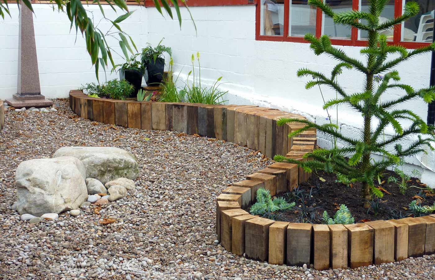 Reclaimed oak beams contain the planting areas and provide seating