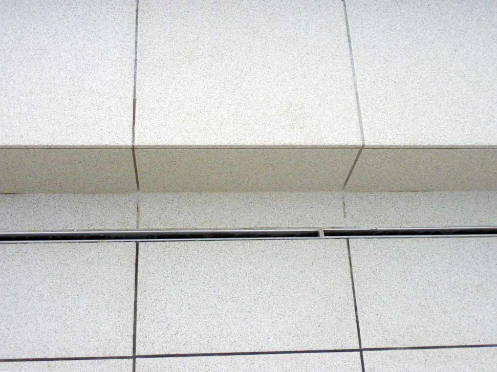 Discreet drainage channel in porcelain tiles for modern garden