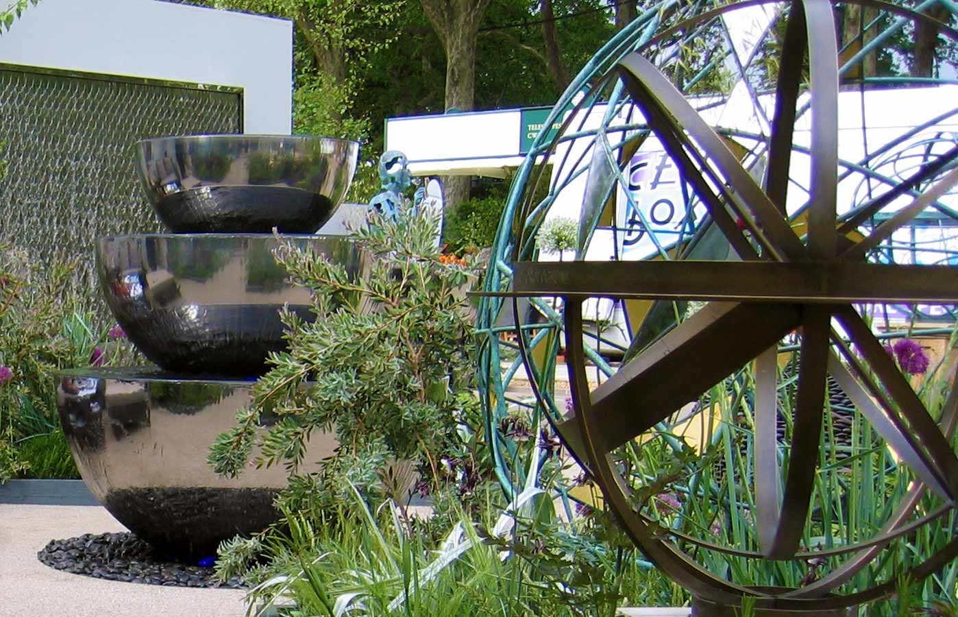 Water sculptures and armillary spheres on resin bonded aggregate softened by planting